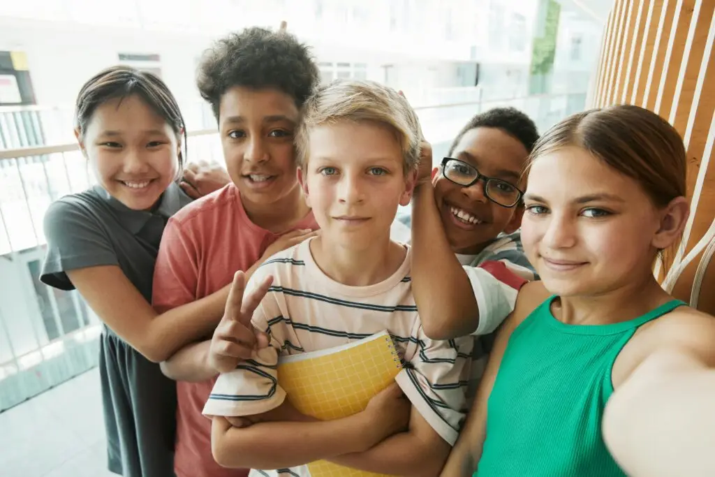 Happy multicultural group of kids smiling together inside a modern building.